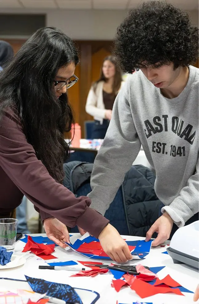 Two students making red, white, and blue quilts