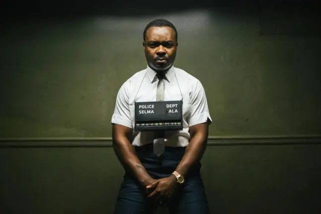 Film still from movie showing MLK Jr. figure staring into camera for mugshot